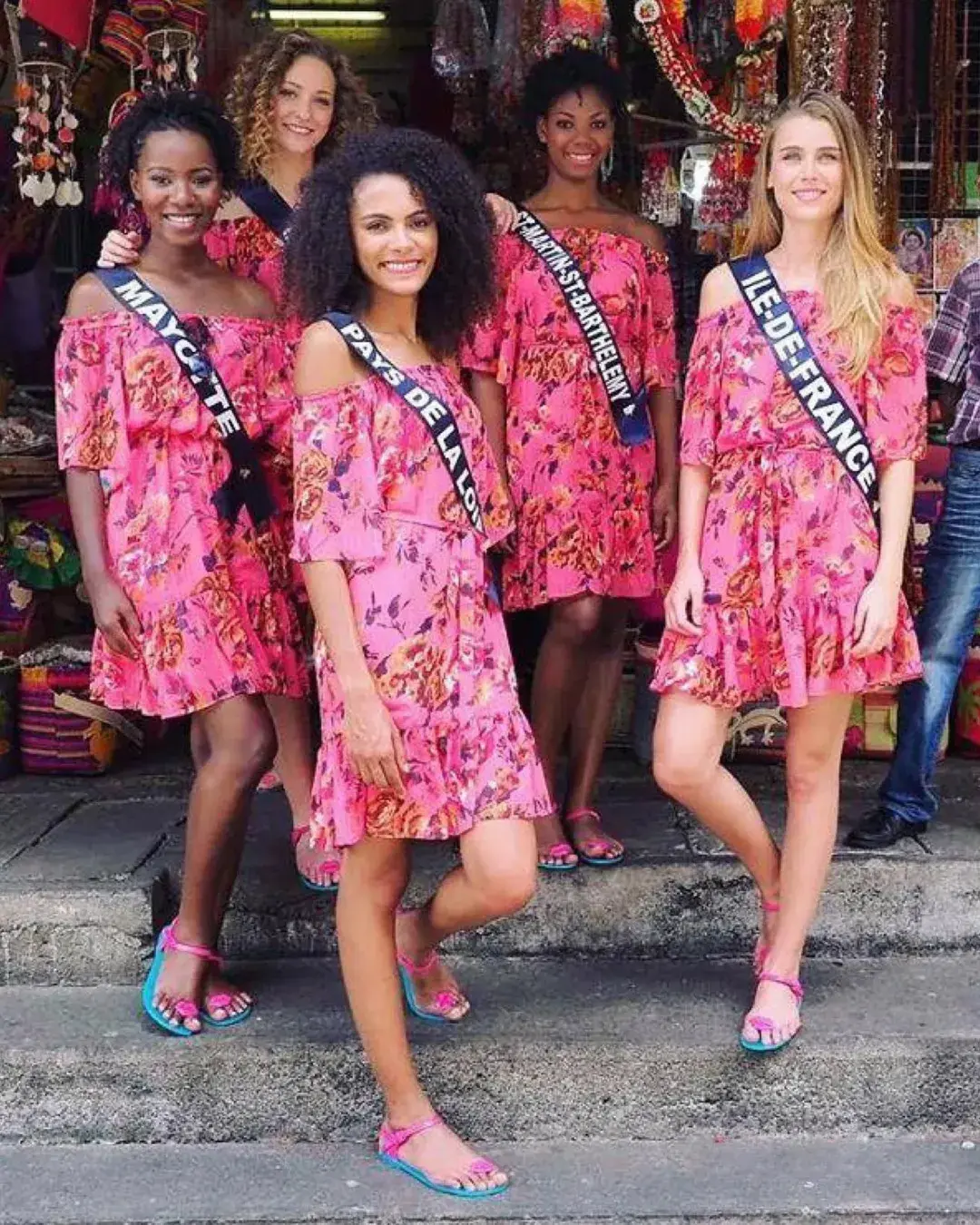 A group wearing colorful pink outfits and ZHOELALA sandals.